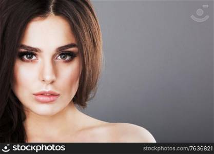 Beautiful brunette woman portrait, healthy hair, clear fresh skin, girl on gray background with copy space for text, skincare., spa, beauty model. Beautiful brunette woman portrait