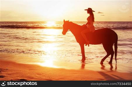 Beautiful brunette woman riding a horse and watching a sunset