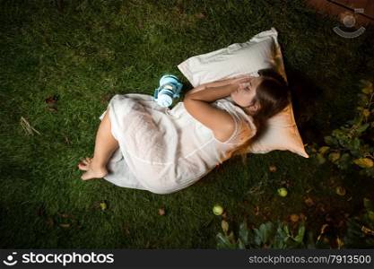 Beautiful brunette woman sleeping at night garden on pillow