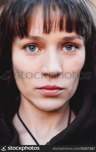 Beautiful brunette woman with blue eyes in the park