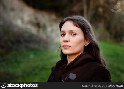 Beautiful brunette woman with blue eyes in the park