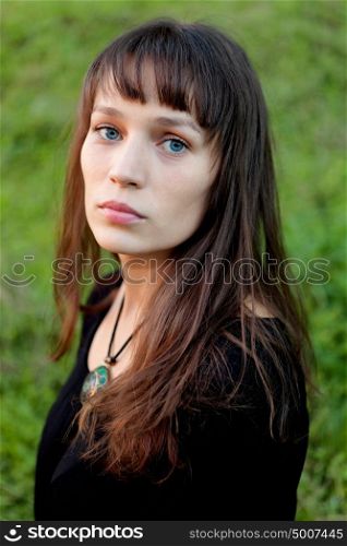 Beautiful brunette woman with blue eyes in the park