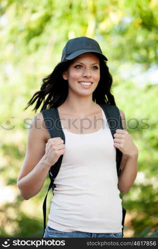 Beautiful brunette woman with cap and backpack hiking