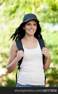 Beautiful brunette woman with cap and backpack hiking