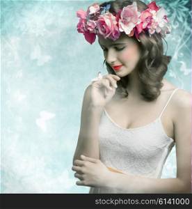 Beautiful, brunette woman with colorful makeup, wreath of flowers on head, little bird on her finger and wearing white dress.