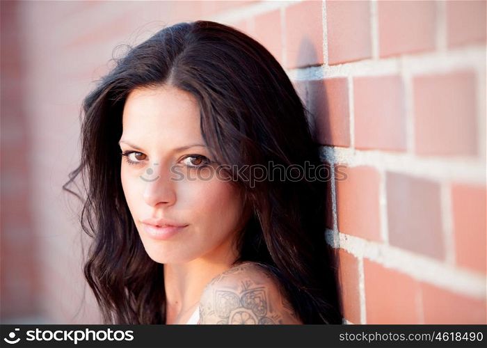 Beautiful brunette woman with tight shirt on red brick wall background