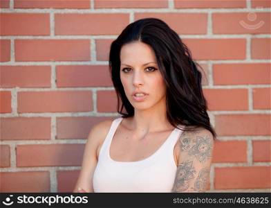 Beautiful brunette woman with tight shirt on red brick wall background