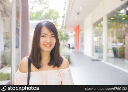 Beautiful brunette young woman wearing dress and walking on the street.