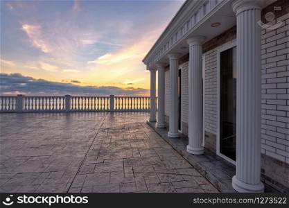 Beautiful building with columns on a landscaped promenade at sunset