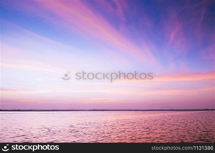 Beautiful burning dramatic sunrise or sunset sky over wide peaceful Nong Harn lake, Udonthani - Thailand.