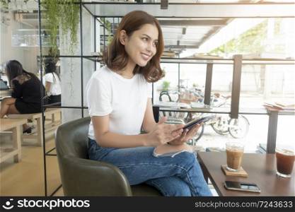 Beautiful business girl working with tablet , smartphone and drinking coffee in coffee shop
