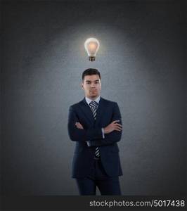 Beautiful business man with idea light bulb above head on gray background