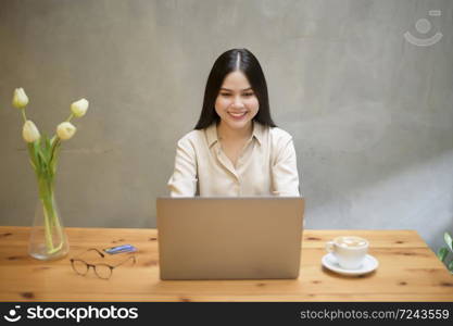 Beautiful business woman is working with laptop in coffee shop
