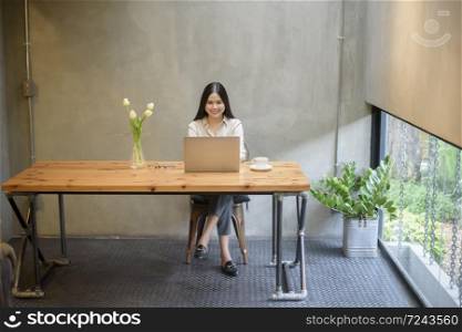 Beautiful business woman is working with laptop in coffee shop
