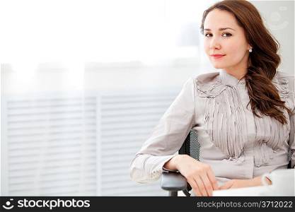 Beautiful business woman sitting at office, window outside background