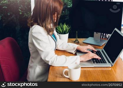 Beautiful business woman sitting working using laptop computer on desk office