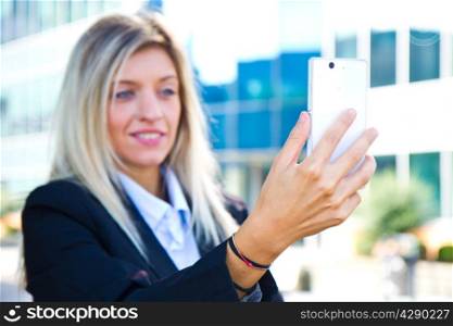 Beautiful business woman takes a selfie with her cell phone