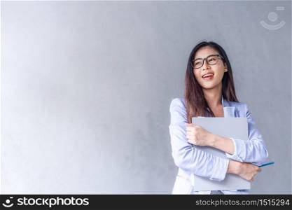 Beautiful business woman wears glasses to be a happy Asian smile In the mobile, the file is in the office On a gray background