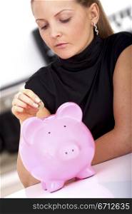 beautiful business woman with a piggy bank at home