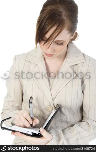 Beautiful business woman writing in datebook.