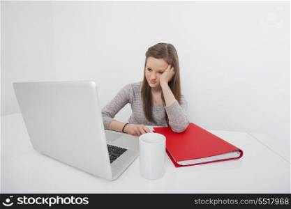 Beautiful businesswoman looking at laptop in office