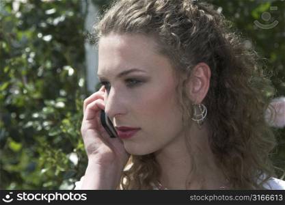 Beautiful businesswoman talking on the phone outdoors during her lunchbreak in the park