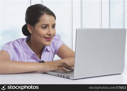 Beautiful businesswoman using laptop at office desk