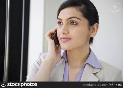 Beautiful businesswoman using mobile phone in office