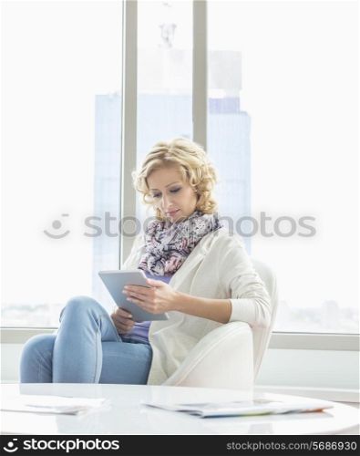 Beautiful businesswoman using tablet PC at creative office lobby