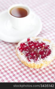 beautiful cake with berries and tea on plaid fabric