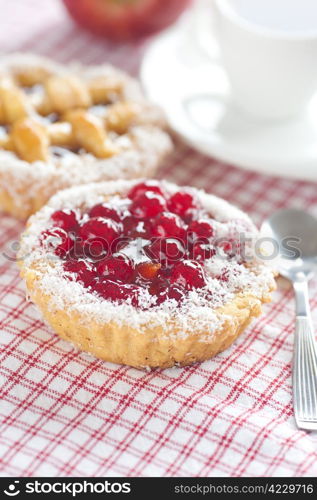 beautiful cake with berries and tea on plaid fabric