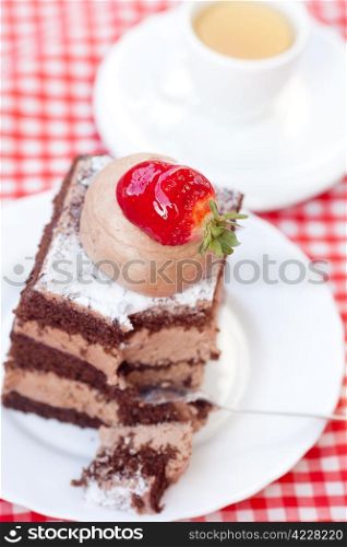 beautiful cake with strawberry and tea on plaid fabric