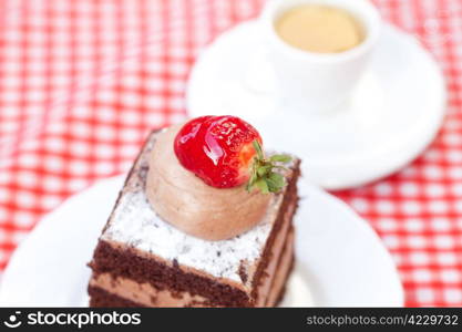 beautiful cake with strawberry and tea on plaid fabric