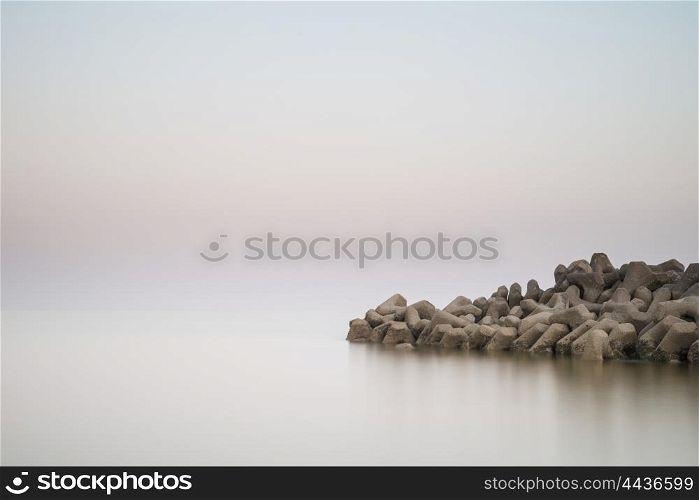Beautiful calm landscape of rocky outcrop into sea