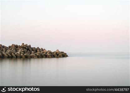 Beautiful calm landscape of rocky outcrop into sea