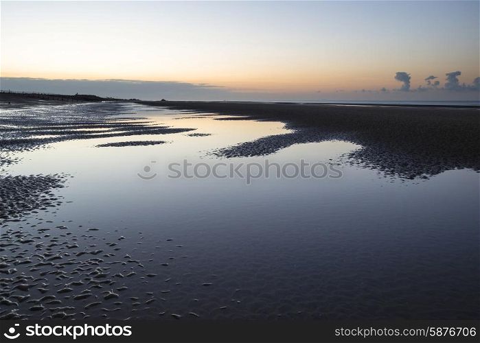 Beautiful calm sunrise over low tide beach