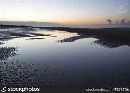 Beautiful calm sunrise over low tide beach