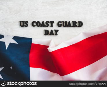 Beautiful card for US Coast Guard Day. Wooden letters with a congratulatory inscription on a white background. Close-up, top view. Congratulations for loved ones, relatives, friends and colleagues. Beautiful, bright greeting card with a holiday