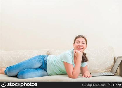 beautiful carefree girl lying on the sofa in the living room
