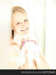 Beautiful caucasian female showering, smiling and looking to the camera