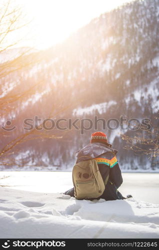 Beautiful Caucasian girl is sitting in the snow. Winter landscape, Austria