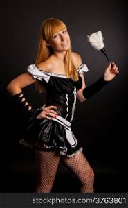 Beautiful caucasian woman dressed in a French Maid costume isolated on a black background
