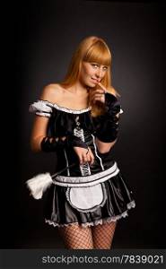Beautiful caucasian woman dressed in a French Maid costume isolated on a black background