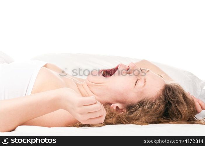 beautiful caucasian woman is lying in bed at morning and yawning