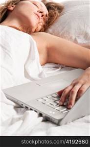 beautiful caucasian woman is lying in bed at morning with laptop