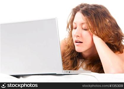 beautiful caucasian woman is working on laptop and lying in bed at morning