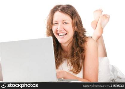 beautiful caucasian woman is working on laptop and lying in bed at morning