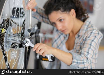 beautiful cheerful woman checking bicycle wires