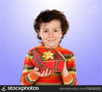 Beautiful child giving a present isolated on blue background