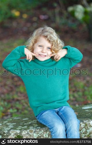 Beautiful child in a park smiling with a green jersey